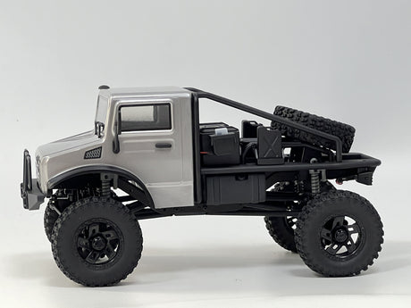 Silver off-road RC truck with rugged, all-terrain tires and a powerful suspension system.