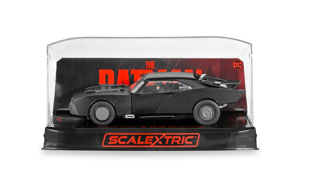 Black Batmobile from the movie "The Batman 2022" on a Scalextric slot car racing track.