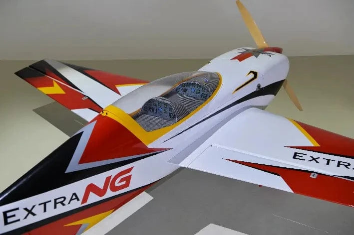 Detailed red, white, and black RC plane model on display, featuring "Extra" branding and sleek carbon fiber design.