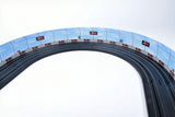 Three sturdy race barriers in the AFX 22049 Race Barriers (3 Pack) product, showcased in the provided image. The curved, blue barriers feature red flags for a realistic racing track scene.