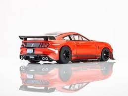Red high-performance slot car, the 2021 Shelby GT500 model by AFX, placed on a reflective surface against a plain background.