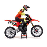 Detailed RC motorcycle with rider in full gear, featuring a sleek red and yellow design.