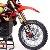 Red and black 1/4 scale Losi Promoto-MX RC motorcycle with detailed off-road tires, suspension, and sleek body design.