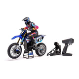 Detailed RC dirtbike with colorful racing graphics and rider, remote control, and accessories displayed on a white background.