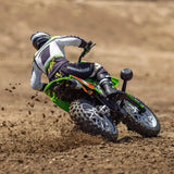 Rugged RC motorcycle: Losi Promoto-MX 1/4 scale bike in Pro Circuit color scheme, racing through dirt track.