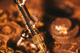 Dual-nozzle Harder and Steenbeck airbrush, featuring 0.28mm and 0.45mm tips, displayed amid a golden, metallic background.