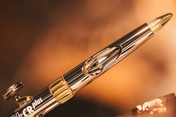 Sleek Harder and Steenbeck Evolution 2024 CRPlus Solo airbrush with 0.28mm nozzle, showcased in a dramatic golden lighting.