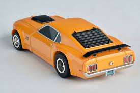 Orange Mustang Boss 428 slot car with sleek design, detailed features, and racing stripes.