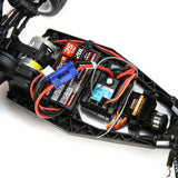 Compact RC buggy with advanced electronics and power components on display.