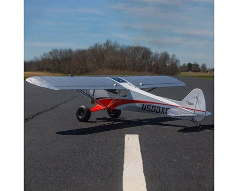 Hangar 9 Cub Crafters XCub 60cc ARF RC Plane on runway, ready for take-off with its impressive wingspan and sleek red and grey design.