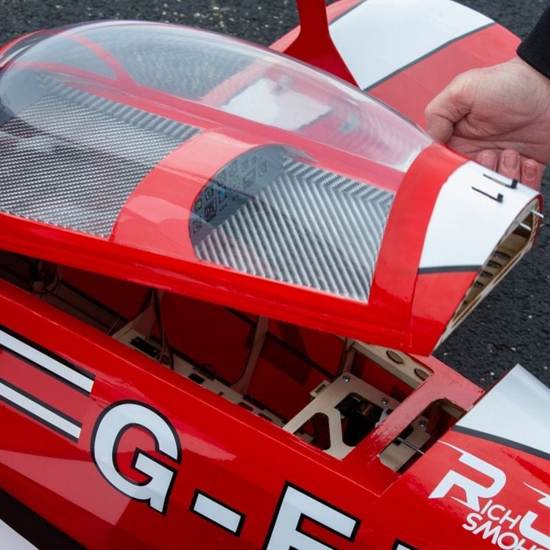 Detailed red and white RC plane model with clear canopy, showcasing its aerodynamic design and robust construction.